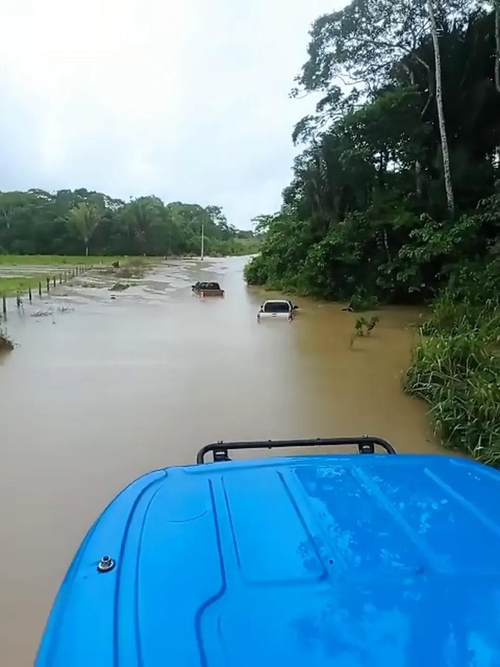 Caminhonetes ficam quase encobertas em rodovia após rio transbordar em RO